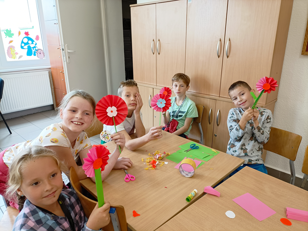 Dzieci tworzą kwiaty z papieru.