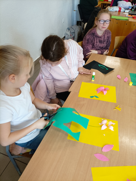 Dzieci tworzą kwiaty z papieru.